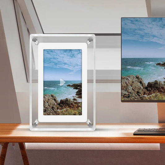 5 inch digital photo frame displaying a beautiful ocean view on a desk with a computer monitor in the background.